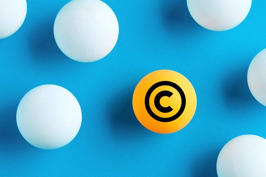 Boule orange portant le symbole du copyright parmi des boules blanches sur fond bleu