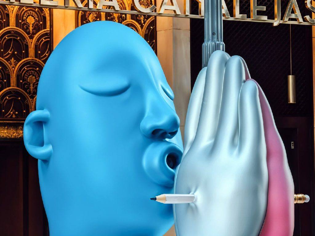 Visage sculpté bleu soufflant un crayon à travers une main, illustration sur l’IA et la créativité